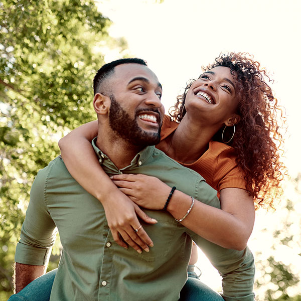 young man giving his girlfriend a piggyback ride